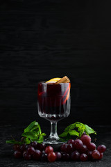 Mulled wine. Hot wine with orange, apple and cinnamon. In the glass. Top view. On a black...