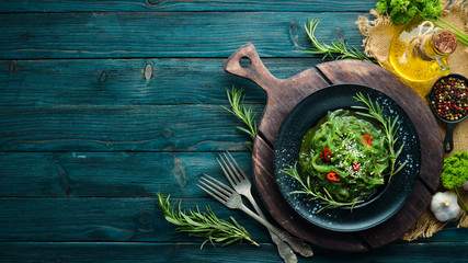 Seaweed salad on a black stone plate. Chinese cuisine. Top view. Free copy space. © Yaruniv-Studio