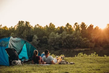  jong gelukkig stel samen kamperen en buiten ontspannen bij de rivier © cherryandbees