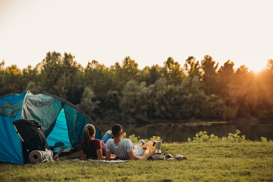 young happy couple camping together and relaxing outdoor by the river