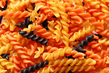 Raw mixed pasta as a background. Top view. Texture, place for text.