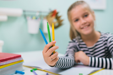 closeup of little girl holding felt pens