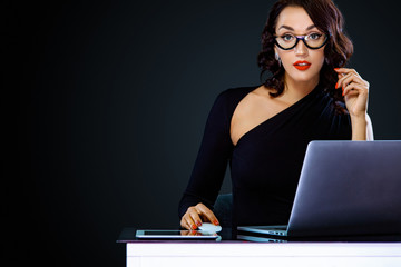 Black friday and cyber monday sale concept for shop. Woman with computer isolated on dark background. Portrait of successful businesswoman in glasses working with laptop in office