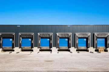 Row of loading docks with shutter doors at an industrial warehouse.