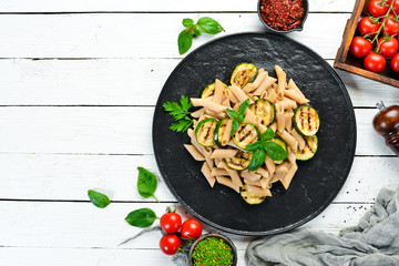 Pasta with baked zucchini. Italian cuisine. Top view. Free space for your text.