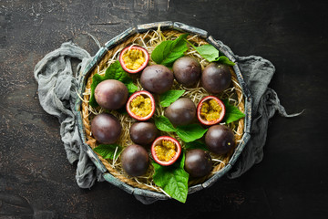 Fresh passion fruit with leaves in Wooden Box. Tropical Fruits. Top view. Free space for text.