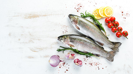 Raw fish with vegetables on a white wooden background. Fish trout. Top view. Free space for your text.