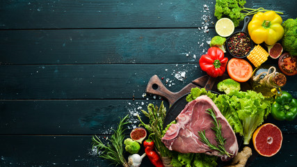 Raw veal steak with vegetables. Healthy eating concept. Top view. Free copy space.