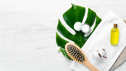 Spa concept. Cosmetic oil, tropical leaf and towel. Top view. Free copy space.