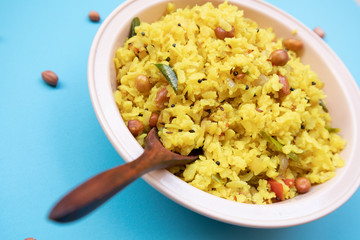 Close up Fresh Poha an South Indian breakfast on bowl with spoon.