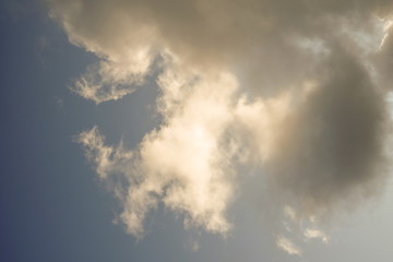 The sun and clouds on the blue sky. Cloudy weather with cumulus, dark clouds. Autumn day. A strong...