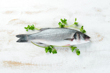 fish seabass with spices. Seafood on a white wooden background. Top view. Free copy space.
