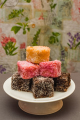 Colourful Australian dessert Lamingtons stacked and served on a cake stand 