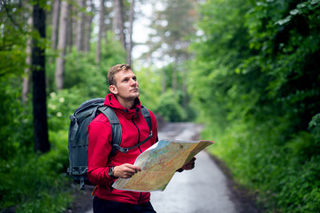 Traveler man using map in a forest