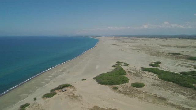 Aerial view of beautiful lonely beach and Paoay sand dune. Philippines, Luzon. Sand dunes near to the sea with sky. Ilocos Norte.
