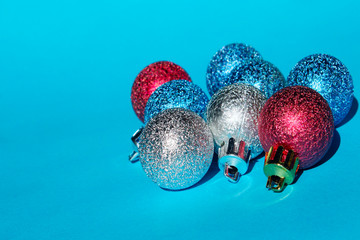 Christmas decoration over blue background. Holidays, Christmas toys concept. Blue, red and silver Christmas balls over blue background.