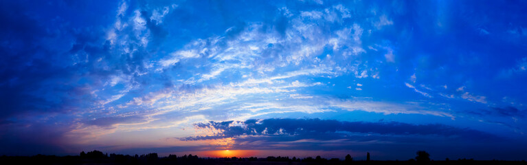 Bright sunlight through the clouds against a breathtaking evening sky at sunset. panorama, natural composition