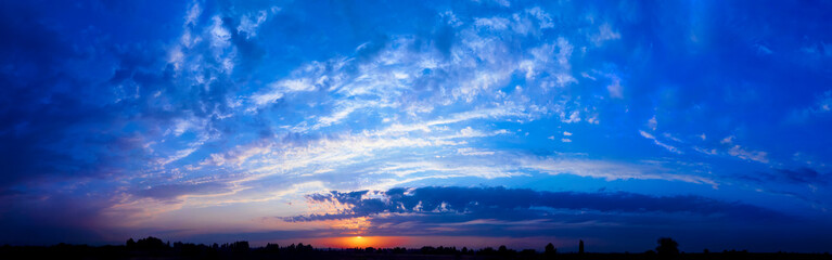 Fototapeta premium Bright sunlight through the clouds against a breathtaking evening sky at sunset. panorama, natural composition