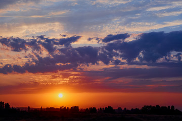 Fototapeta premium Bright sunlight through the clouds against a breathtaking evening sky at sunset. panorama, natural composition