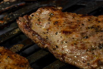 The meat is cooked on a gas grill close-up, a large piece. Barbecue, delicious juicy grilledю