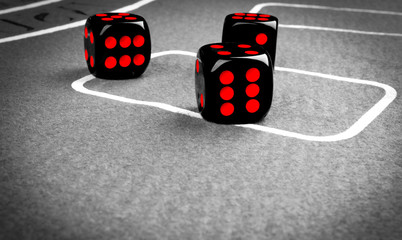 Playing dice on a gaming table. Playing a game with dice. Red casino dice rolls. Rolling the dice concept for business risk, chance, good luck or gambling.