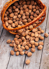 Walnuts in a wicker basket on a wooden background. Close-up