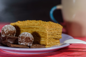 A piece of sponge cake lying on a plate, on a wooden background.