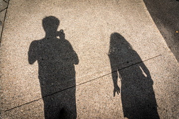 shadow of a man and a women walking on the street