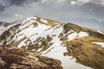 Impressive view from a Midzor summit, the highest peak of Old mountain, during transition period between winter and spring with some remaining snow and sunlit highlands