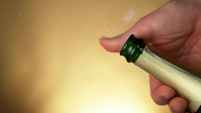 Super slow motion of Champagne explosion, opening champagne bottle closeup. Filmed on high speed cinema camera, 1000fps