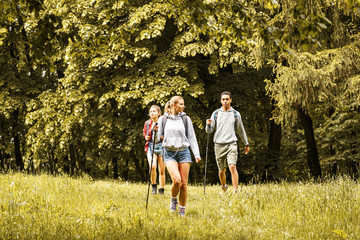 Group of friends hiking in nature.Girl with blond hair lead the group.