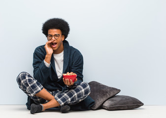 Young black man sitting and having a breakfast shouting something happy to the front