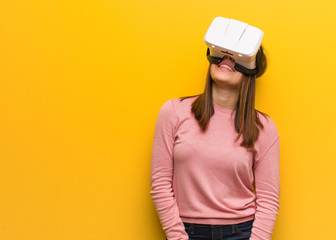 Young cute woman wearing a virtual reality googles cheerful with a big smile