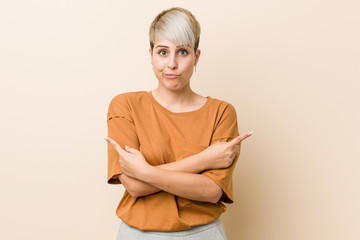 Young plus size woman with short hair points sideways, is trying to choose between two options.