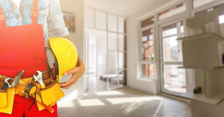 Builder handyman with construction tools. House renovation background.