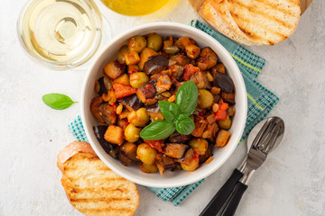 Traditional sicilian eggplant dish Caponata in bowl on concrete background. Top view.