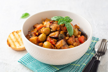 Traditional sicilian eggplant dish Caponata in bowl on concrete background. Selective focus.