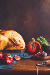 Festive table for Thanksgiving Holiday with whole roasted turkey with apple, pumpkin, figs and...
