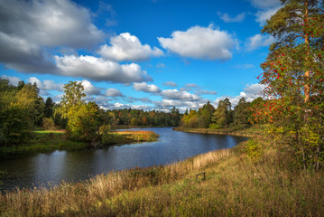 Idyllic autumn landscape with lake and dramatic clouds. 