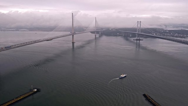 Still shot drone hover over water between Queensferry and Forth Road bridge Edinburgh boat in water