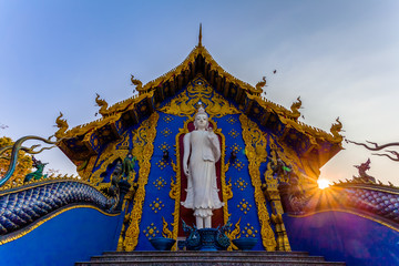 Fototapeta na wymiar white standing buddha on the back of church in Rong Suea Ten temple Chiang Rai Thailand.
