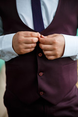 man puts on a suit on the wedding day