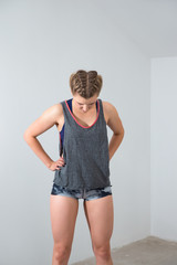 Young blonde woman in boxer braids resting after workout, wearing comfortable sporty outfit.