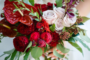 Beautiful wedding bouquet of flowers in the hands of the newlyweds