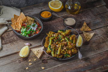 Middle eastern fried cauliflower with green onion, dark photo