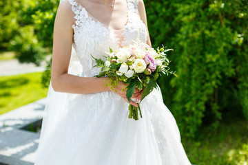 Beautiful wedding bouquet of flowers in the hands of the newlyweds