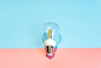 Light bulb ( lightbulb) on a colored background. Minimal concept.