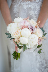 Beautiful wedding bouquet of flowers in the hands of the newlyweds