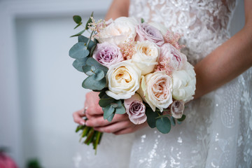 Beautiful wedding bouquet of flowers in the hands of the newlyweds