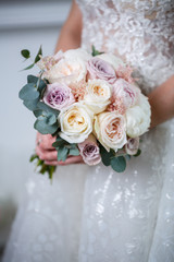 Beautiful wedding bouquet of flowers in the hands of the newlyweds
